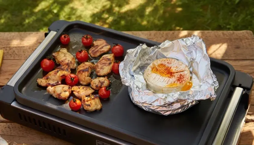 Un camembert fondant à la plancha, entouré de poulet grillé et de tomates cerises. Un délice pour un repas en plein air.