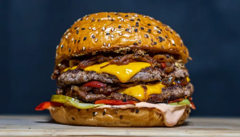 Un double burger gourmand, parfait pour une recette burger maison réussie. Viande juteuse, fromage fondant, oignons caramélisés et sauce onctueuse.