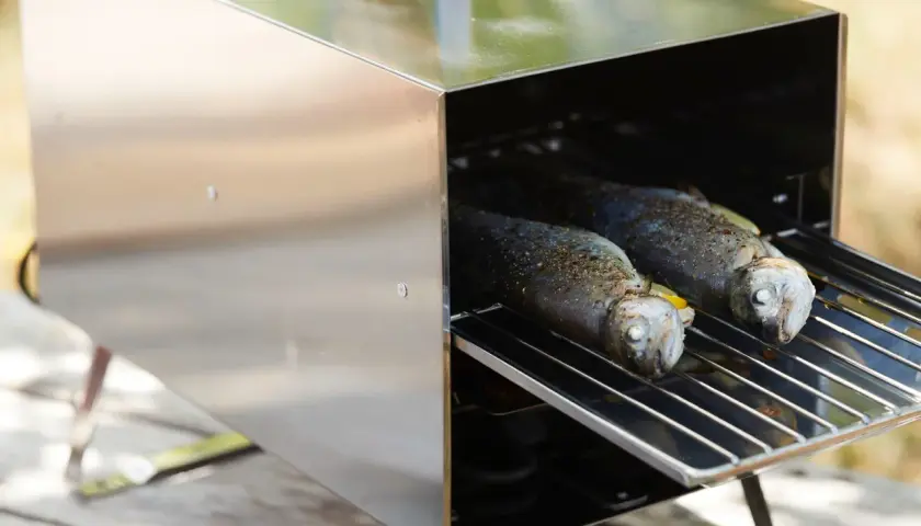 Deux truites assaisonnées sur une grille, prêtes à fumer du romarin pour un goût savoureux.