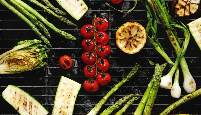 Légumes au barbecue charbon de bois : asperges, tomates cerises, courgettes, oignons nouveaux, citron et chou.