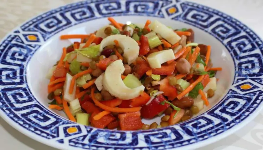 Salade colorée avec des cœurs de palmier, carottes râpées, lentilles et poivrons rouges. Un délice frais et sain.