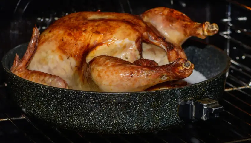 Un poulet crapaudine doré et juteux cuit dans un plat au four, prêt à être dégusté.