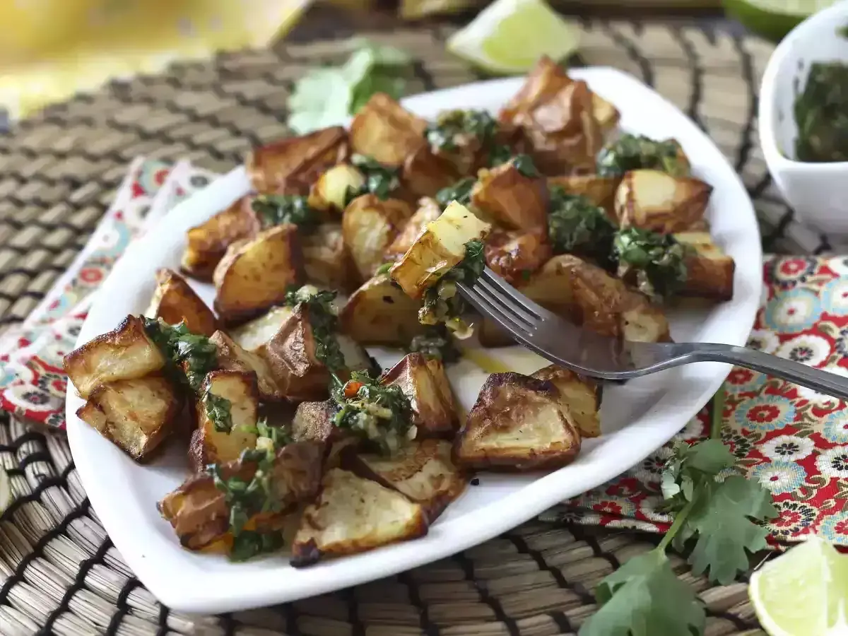 Pommes de terre rôties, garnies d'une sauce verte fraîche, prêtes à être dégustées. Un délice parfait pour un repas d'été, comme un coulommier au barbecue.