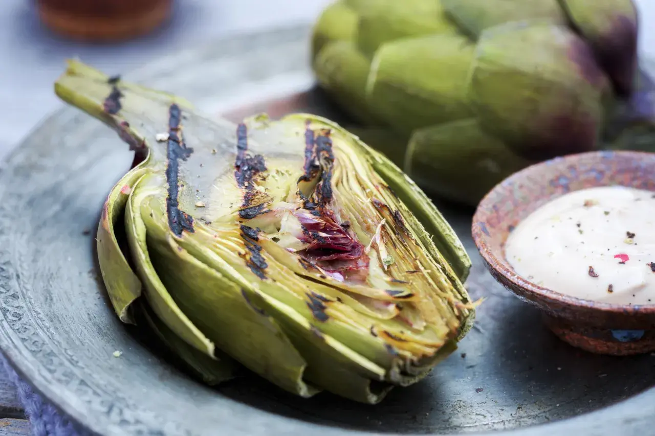 Un délicieux artichaut barbecue, grillé à la perfection, servi avec une sauce crémeuse. Un régal estival !