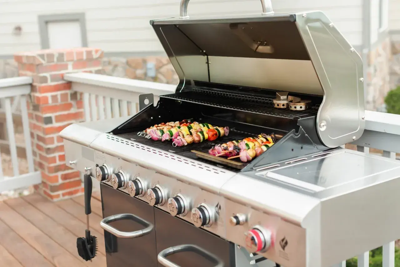 Brochettes colorées en cours de cuisson sur un barbecue à gaz. Les légumes et la viande sont prêts à être dégustés.