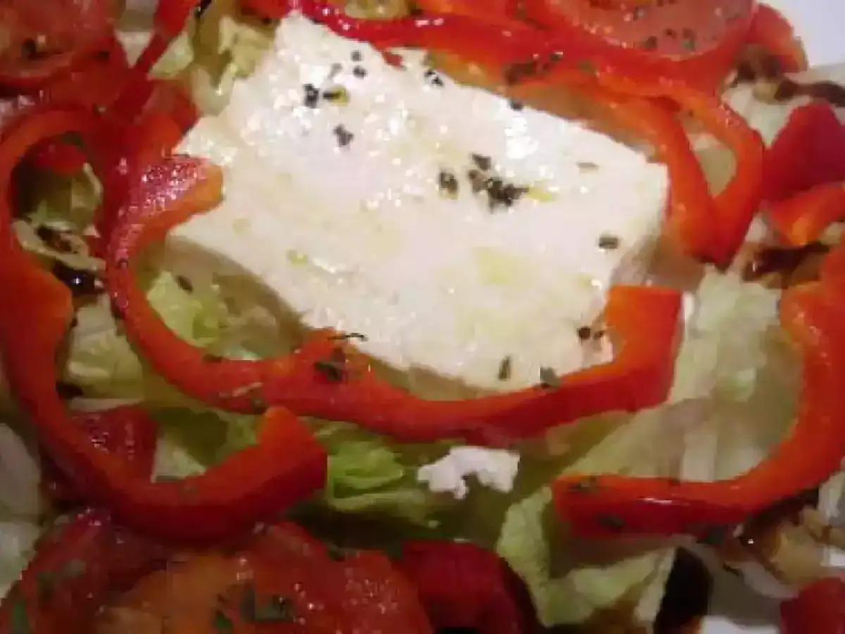 Salade fraîche avec bloc de feta, poivrons rouges, tomates et herbes. Parfait pour un barbecue d'été.