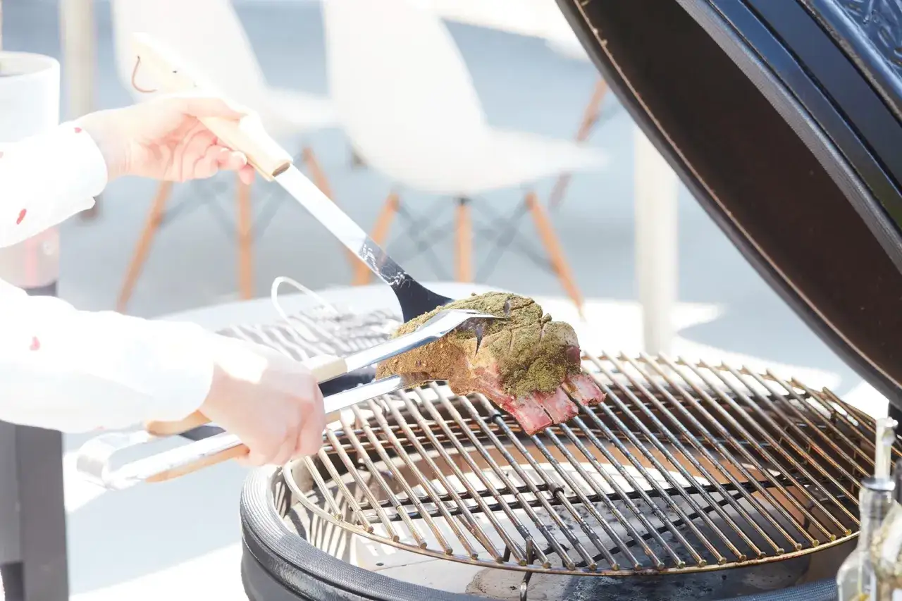 Un rumsteak est placé sur un barbecue, prêt à être grillé.