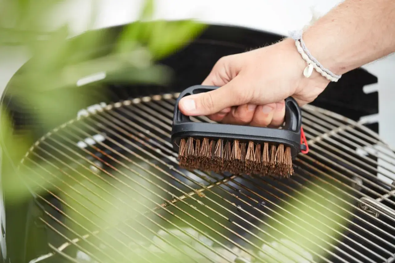 Main tenant, une brosse pour degraisser barbecue, nettoie les grilles avant la prochaine cuisson.