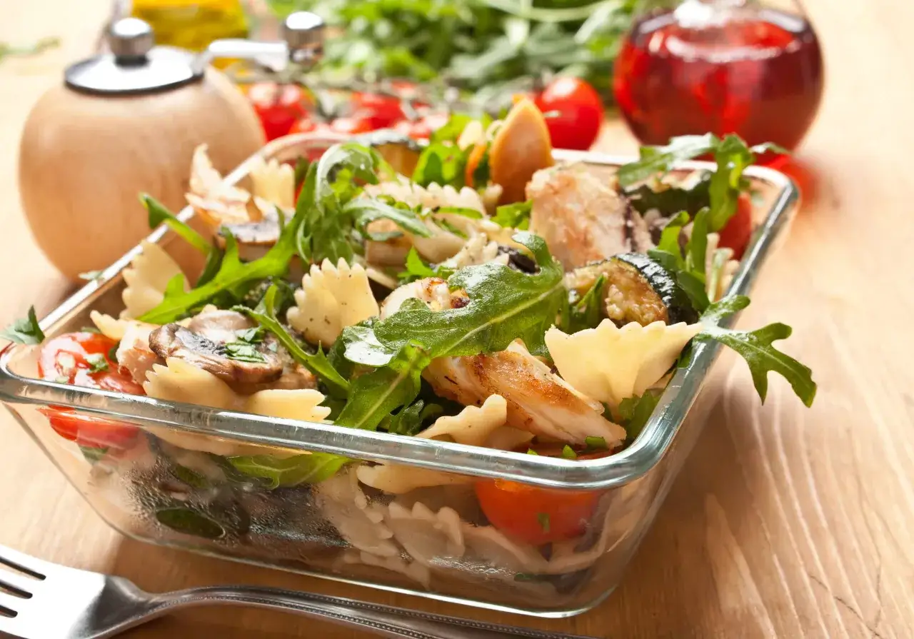 Salade de pâtes farfalle avec poulet fumé, tomates cerises, courgettes grillées et roquette. Une recette légère et savoureuse.
