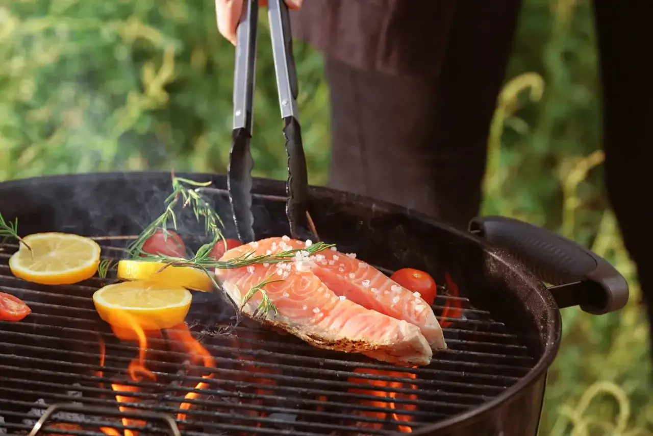 Deux pavés de saumon, citron et tomates cerises sur un barbecue charbon. Quel poisson au barbecue charbon !