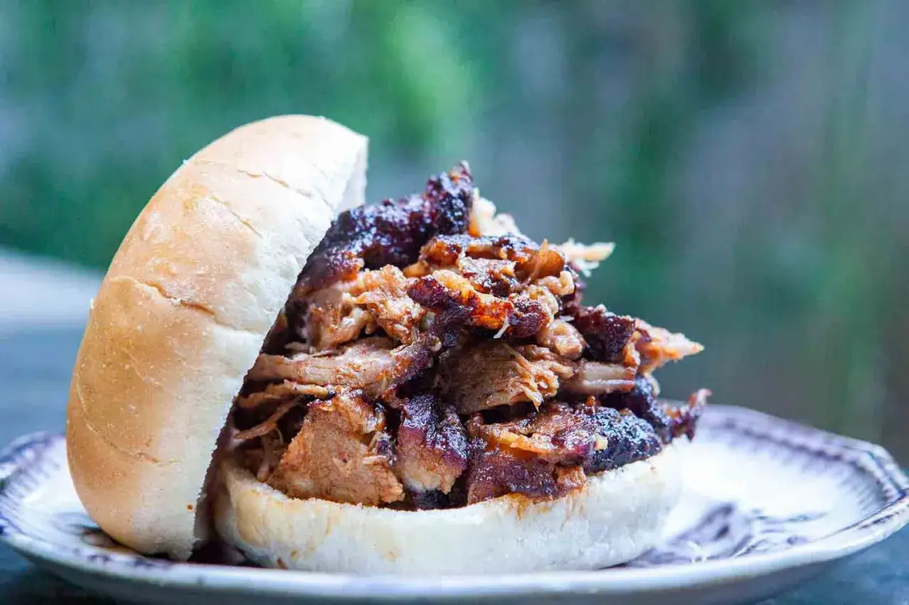 Un généreux sandwich garni de rouelle de porc au barbecue, prêt à être dégusté.