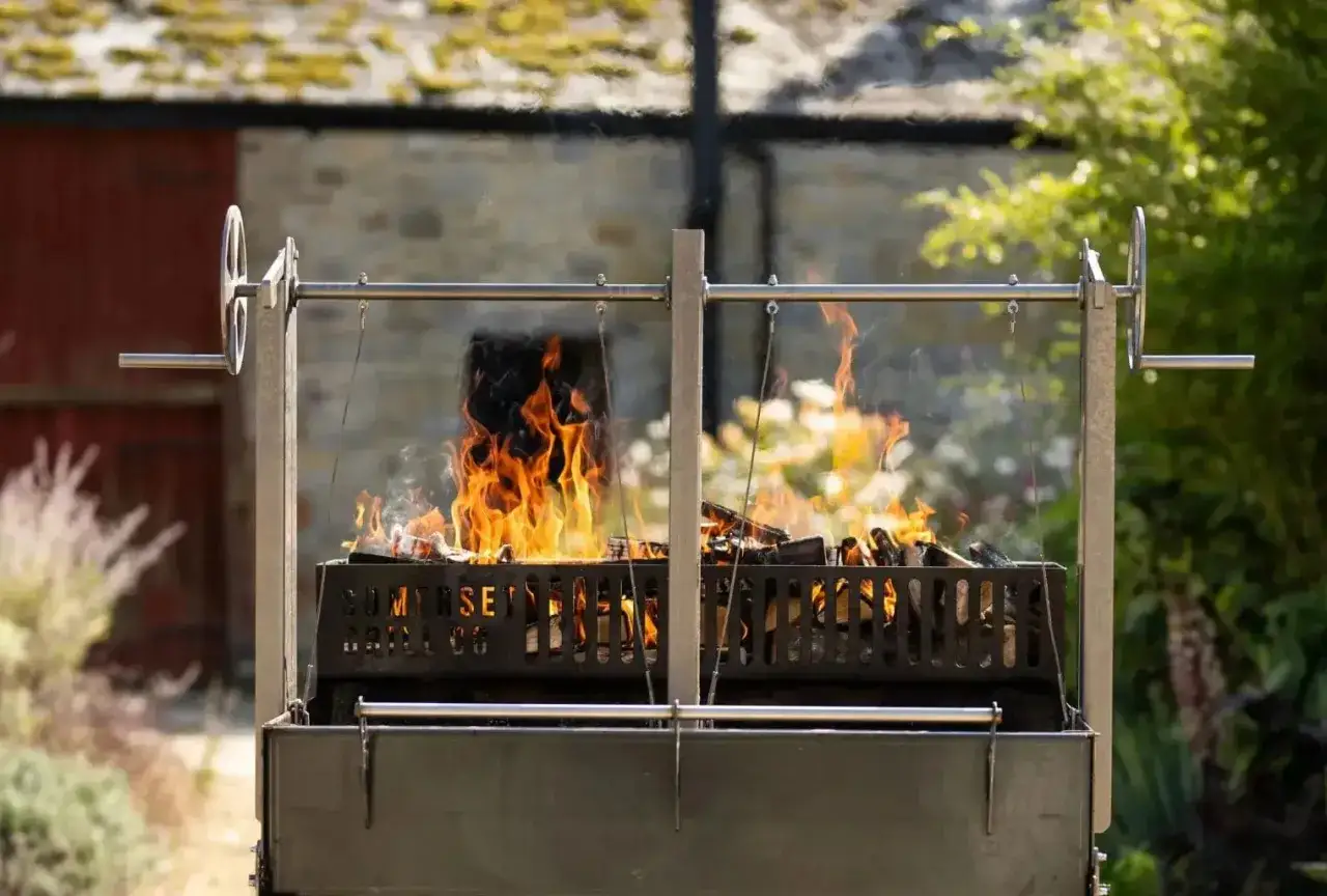 Un barbecue en plein air avec un feu de bois vif. La température monte pour une cuisson parfaite.