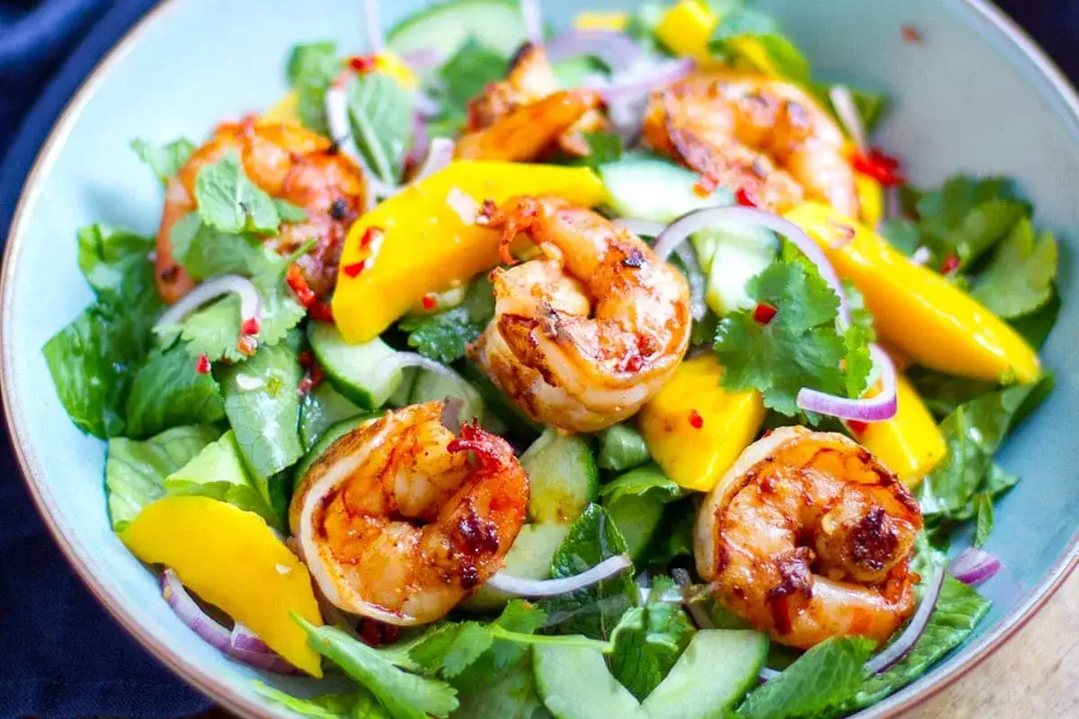 Salade color&eacute;e avec des gambas grill&eacute;es, mangue, concombre, oignon rouge et coriandre. Parfaite salade pour accompagner des gambas grill&eacute;es.