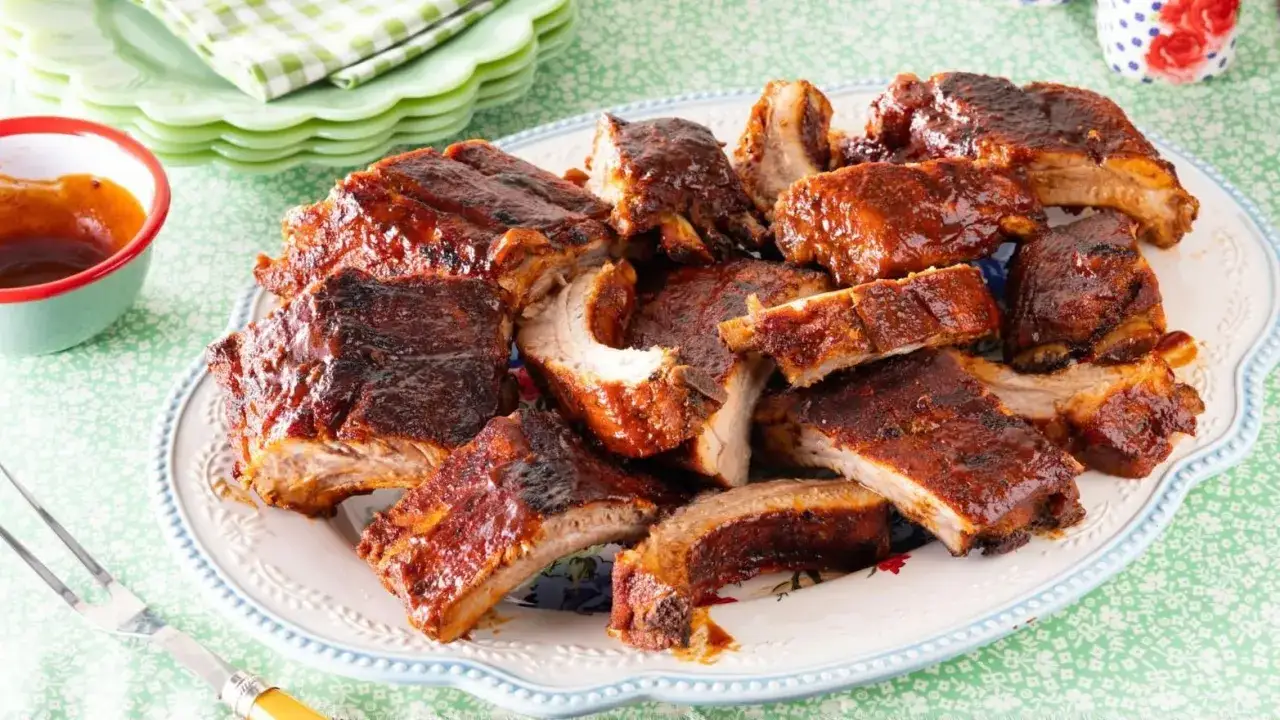 Un plat de ribs de porc grillés, nappés d'une sauce barbecue brillante. Le temps de cuisson parfait pour des ribs tendres et savoureux.