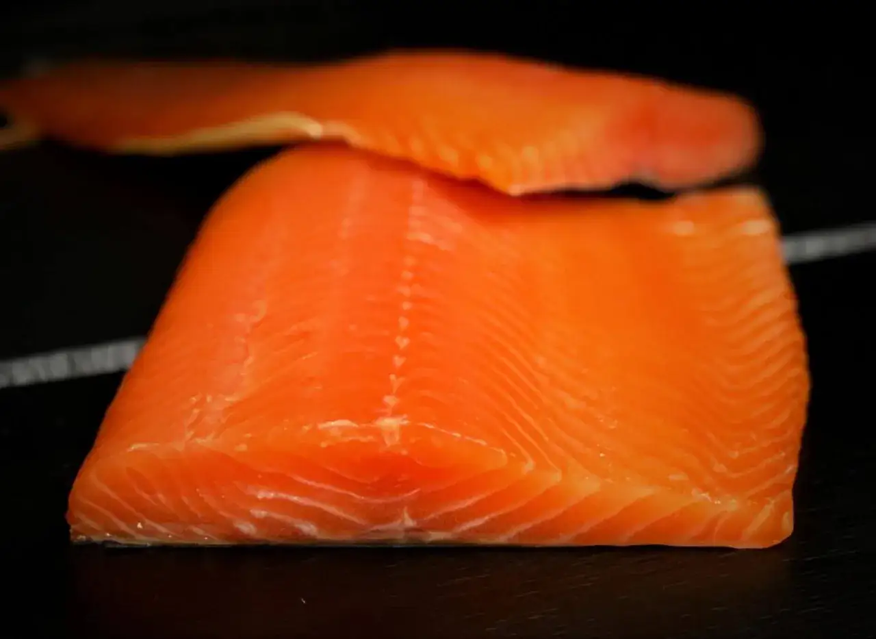 Deux beaux filets de saumon, prêts pour le fumage à chaud. Leur chair orange vif promet une saveur délicate.