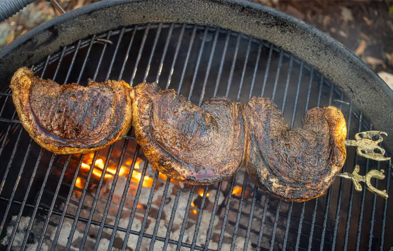 Trois pièces de viande grillées sur un barbecue à gaz avec couvercle. Parfaites pour des recettes barbecue gaz avec couvercle.