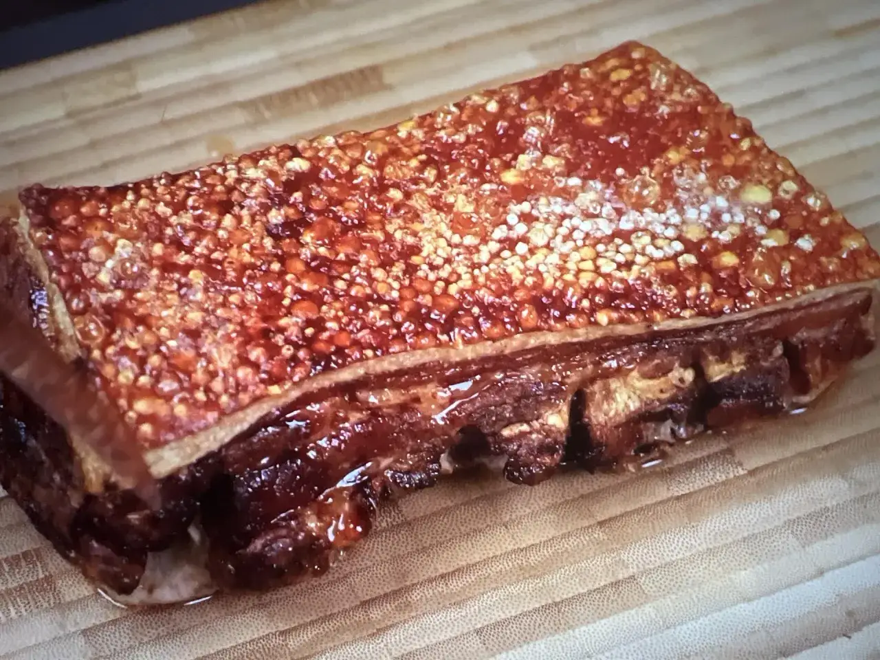 Un morceau de lard barbecue croustillant, prêt à être dégusté. La peau dorée et craquante promet une explosion de saveurs.