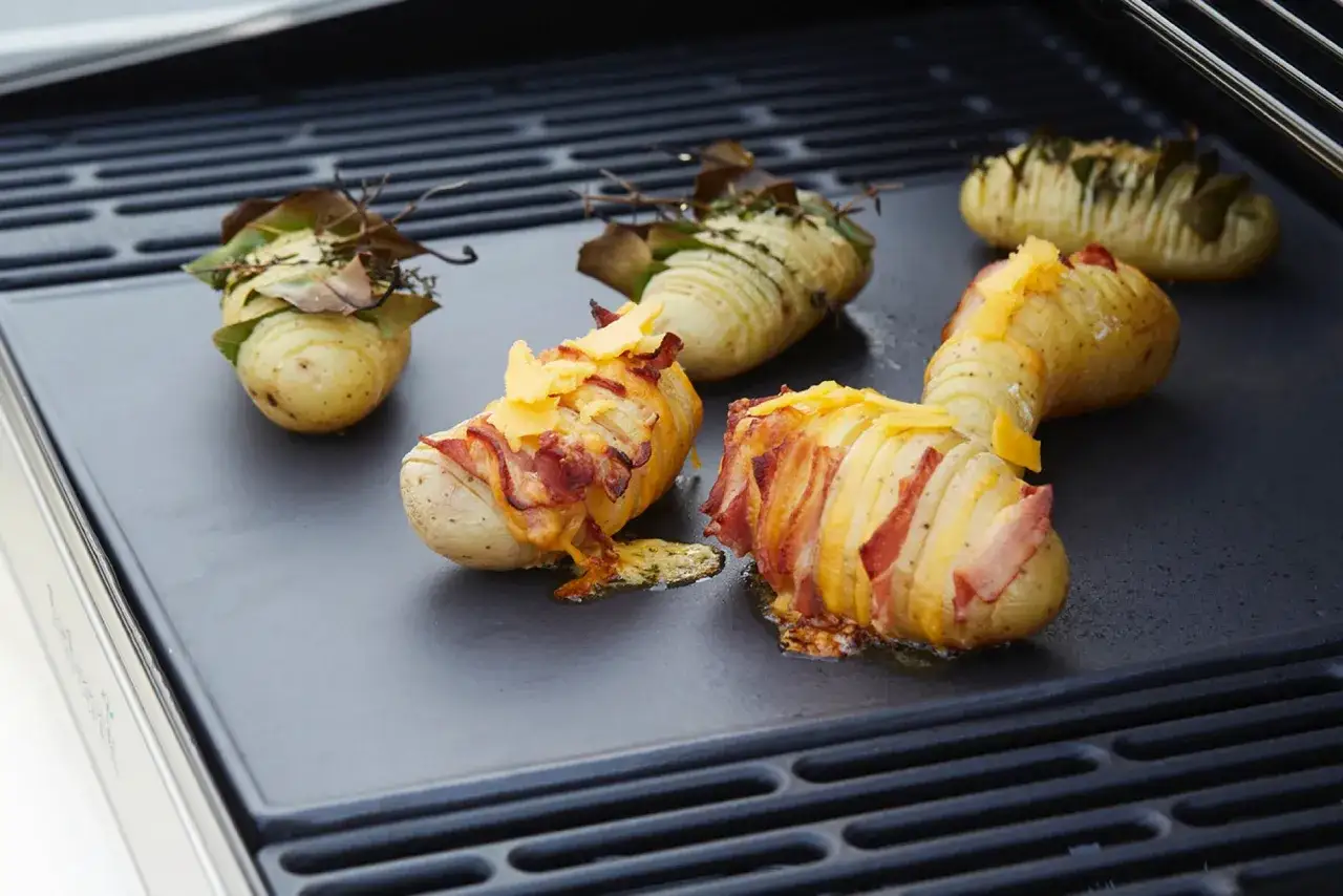 Pommes de terre &agrave; la plancha, coup&eacute;es en accord&eacute;on et garnies de lardons et de fromage fondant. Un d&eacute;lice pour les amateurs de l&eacute;gumes grill&eacute;s.