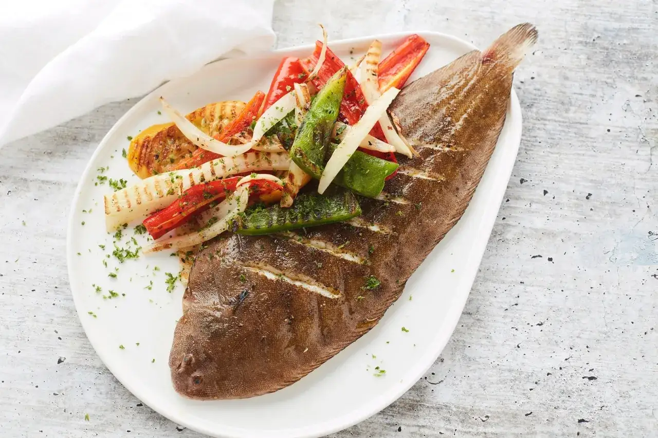 Sole au barbecue, grillée à la perfection, servie avec des légumes croquants et colorés. Un délice estival.
